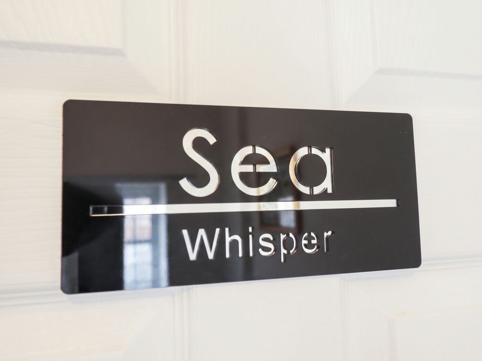 A door sign with the words Sea Whisper at The Ocean House --- Sea Whisper (Top Floor) Le Strange Terrace Hunstanton