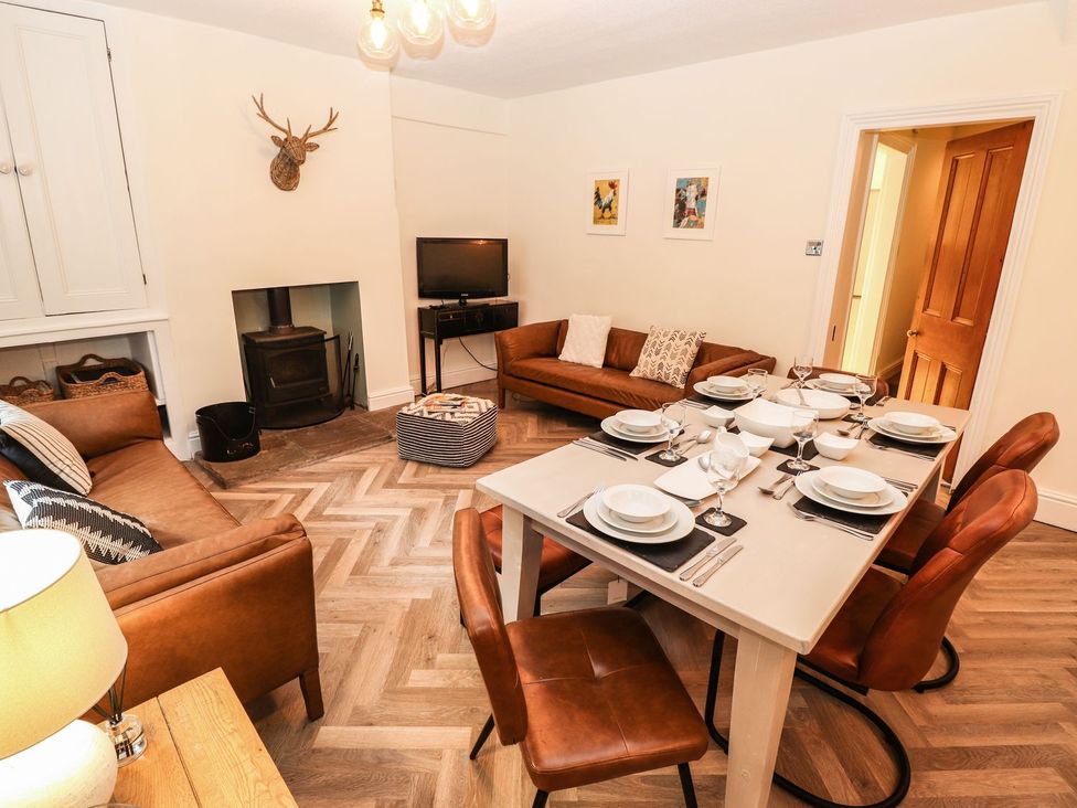 A dining room with a table set for meals at Waterhead Cottage in Ambleside