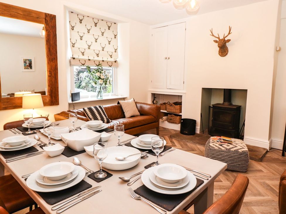 A dining room with a table set for dinner at Waterhead Cottage, Ambleside