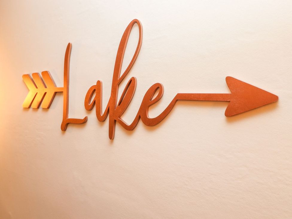 A decorative wooden sign reading 'Lake' with an arrow at Waterhead Cottage in Ambleside