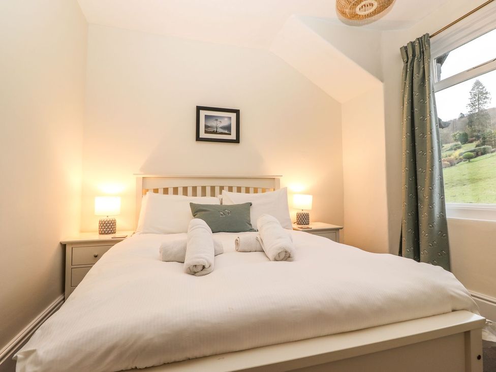 A bedroom with a bed and nightstand at Waterhead Cottage, Ambleside