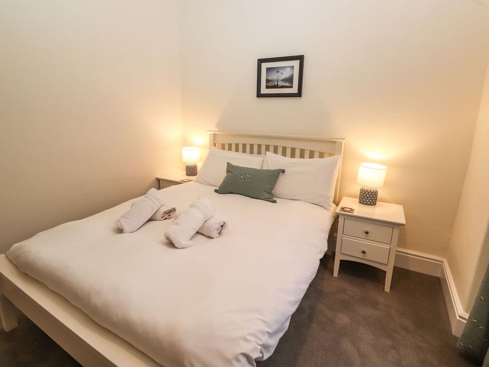 A bedroom with a bed and nightstand at Waterhead Cottage in Ambleside