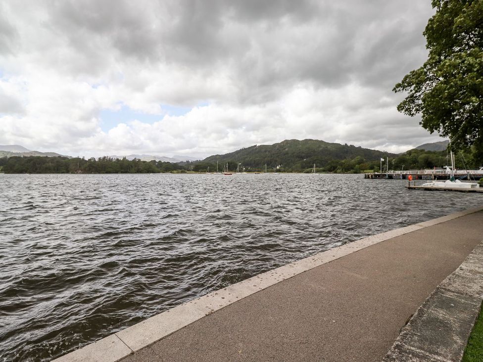 A view of a lake with mountains and a dock at Waterhead Cottage in Ambleside