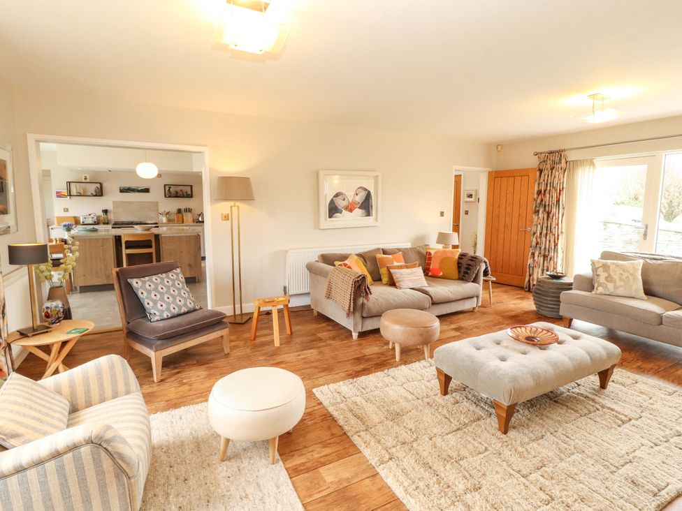 A living room with a sofa and armchairs at Lakes View in Keswick
