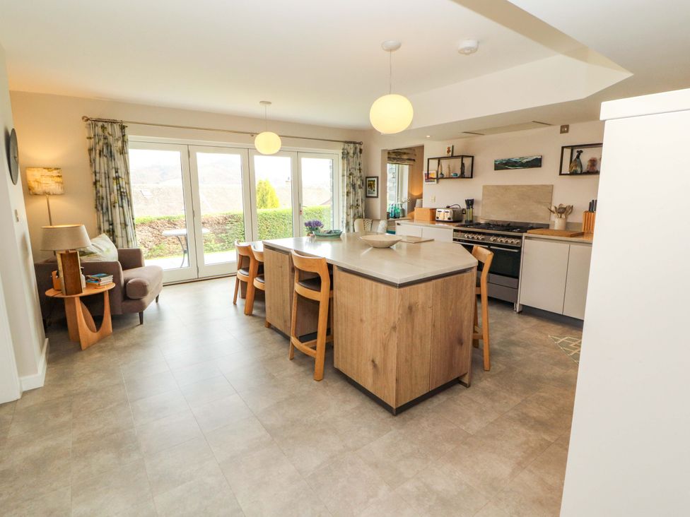 A kitchen with a central island and chairs at Lakes View in Keswick