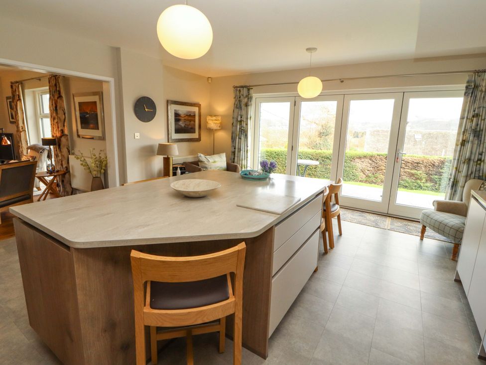 A kitchen with a large island and chairs at Lakes View in Keswick