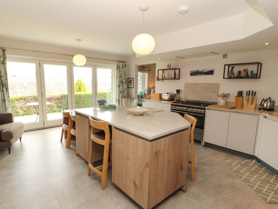 A kitchen with an island and stools at Lakes View in Keswick