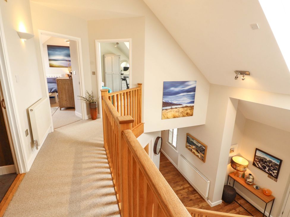 A hallway with a staircase and wall art at Lakes View in Keswick
