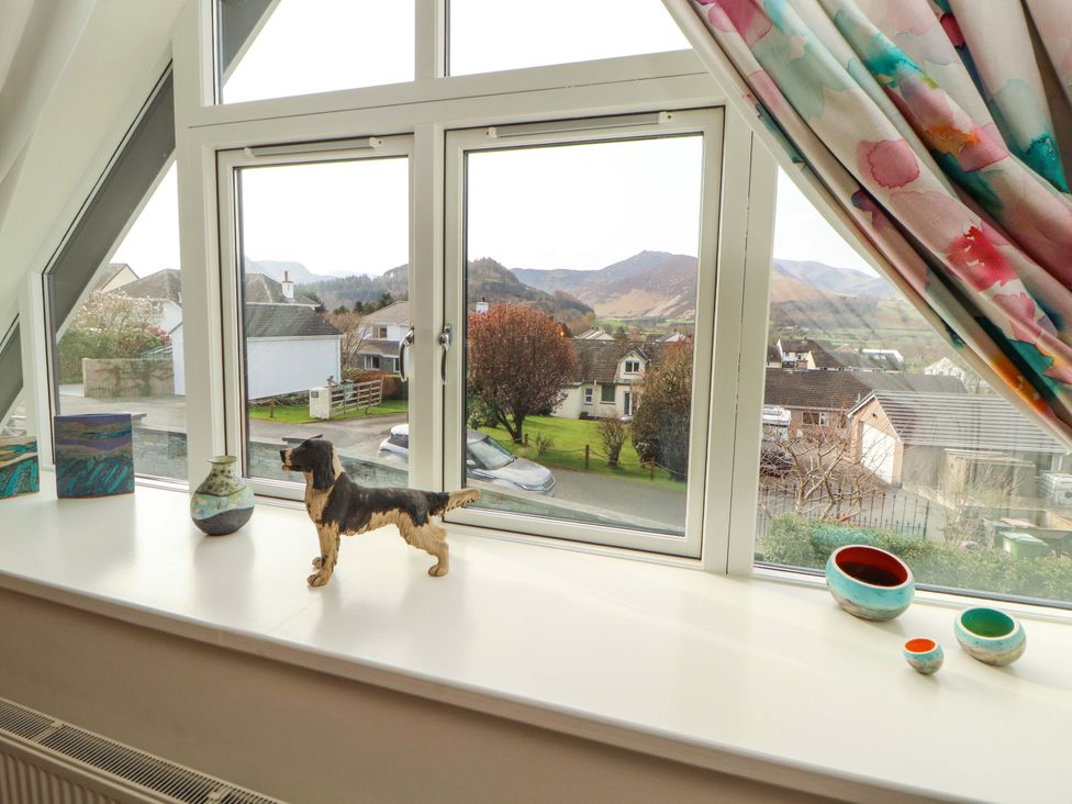 A living room window with a dog figurine and decorative items at Lakes View in Keswick