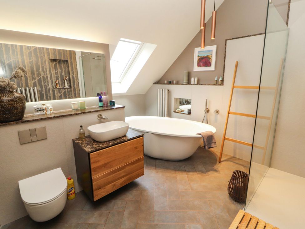 A bathroom with a bathtub, sink, and toilet at Lakes View in Keswick