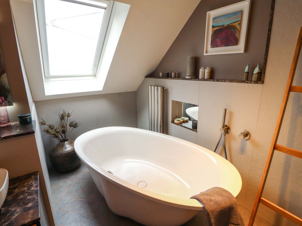 A bathroom with a bathtub and a towel at Lakes View in Keswick