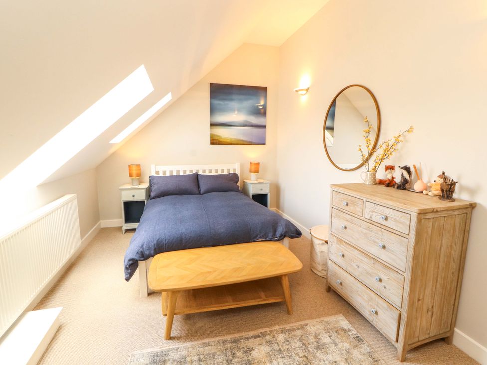 A bedroom with a double bed and a mirror at Lakes View in Keswick