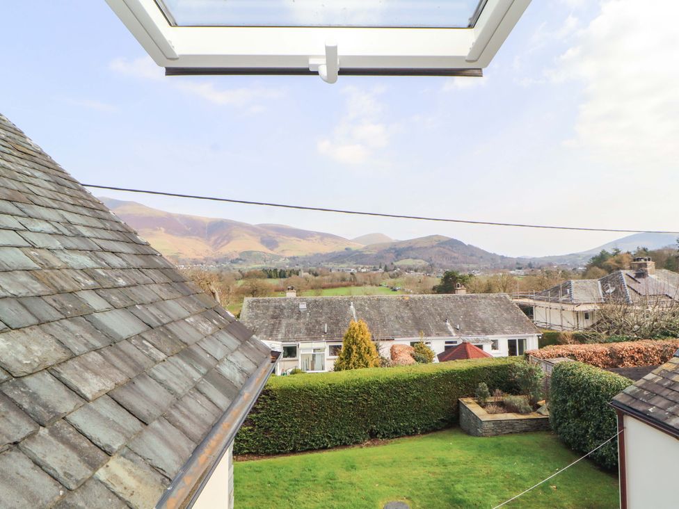 A view of mountains and houses from a window at Lakes View in Keswick