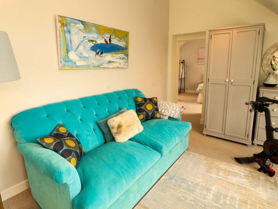 A living room with a sofa and painting at Lakes View in Keswick