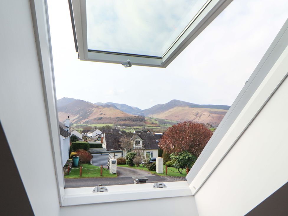 A view from a window showing mountains and houses at Lakes View in Keswick