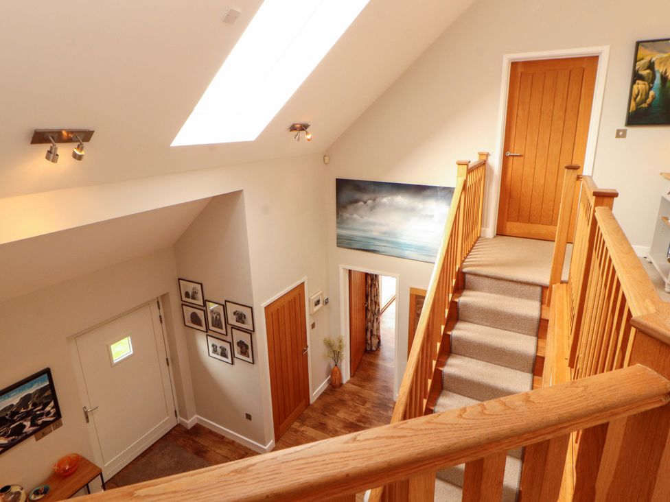A hallway with stairs and wall art at Lakes View in Keswick