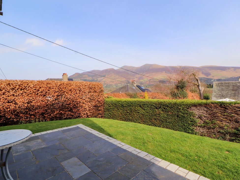A garden with a patio and view of a mountain range at Lakes View in Keswick