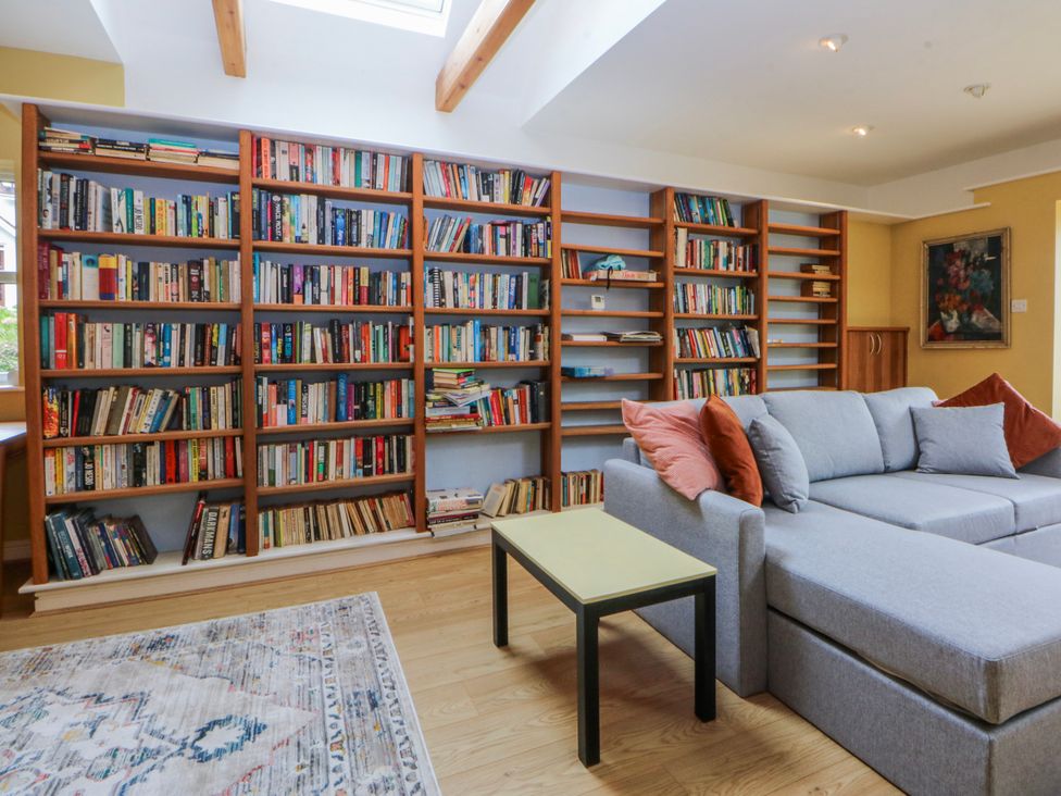A living room with bookshelves and a sofa at Inglewood Bach in Conwy