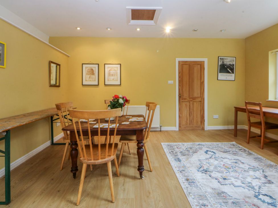 A dining room with a table and chairs at Inglewood Bach in Conwy
