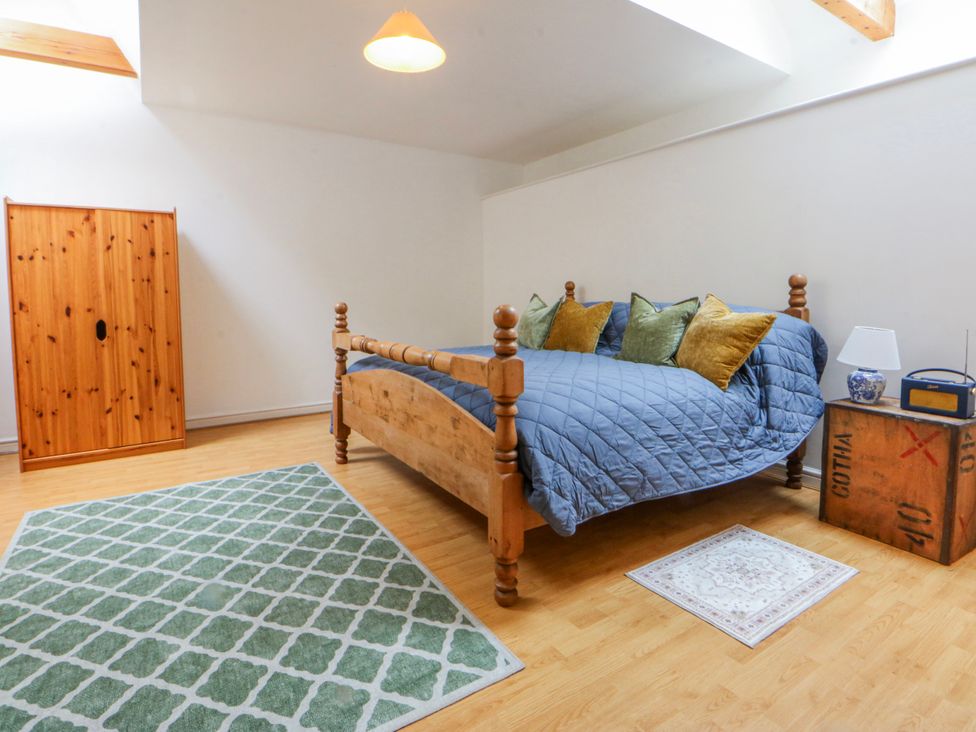 A bedroom with a bed and wardrobe at Inglewood Bach, Conwy