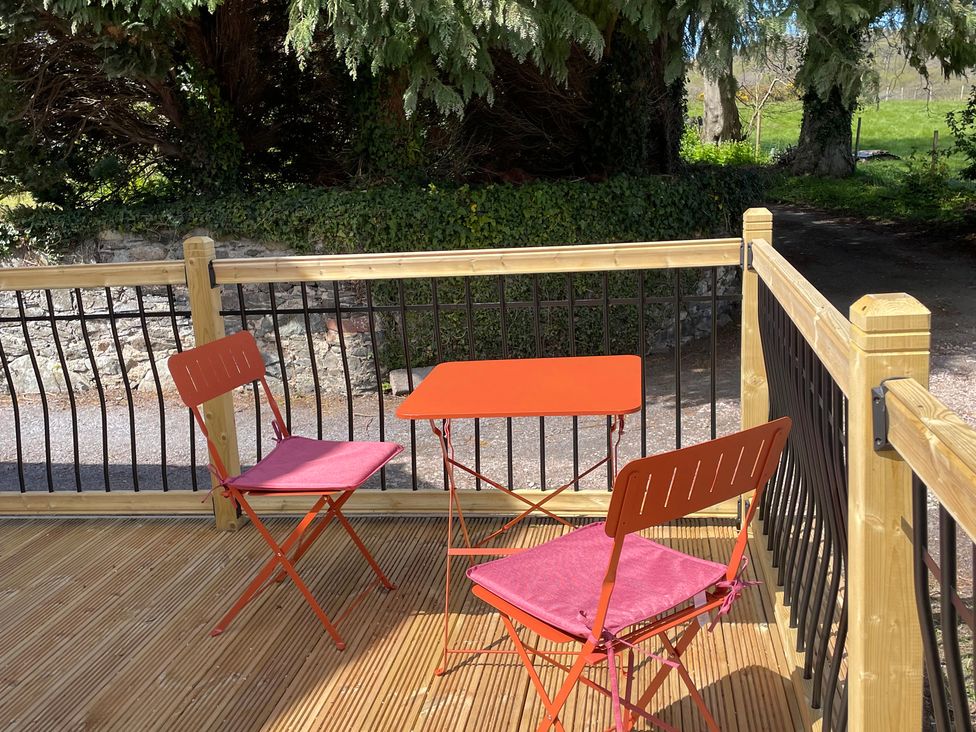 An outdoor seating area with a table and chairs at Inglewood Bach in Conwy