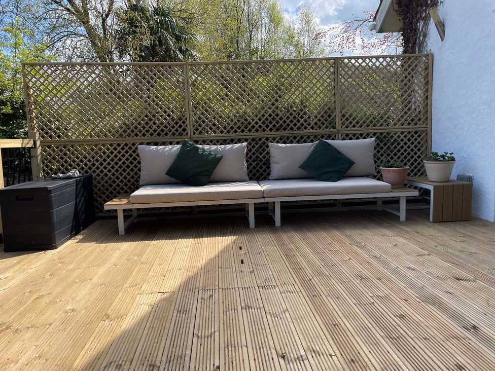 A seating area with a sofa and planters at Inglewood Bach in Conwy