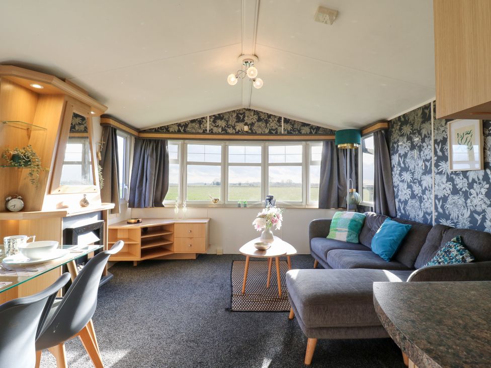 A living room with a sofa, coffee table, and windows at Granada at Avalon Eco Farm Cambridge