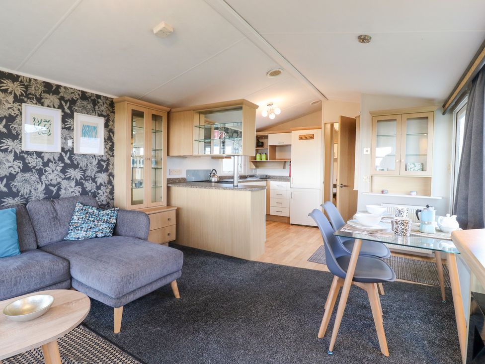 A living room with a kitchen area and table set at Granada at Avalon Eco Farm in Cambridge