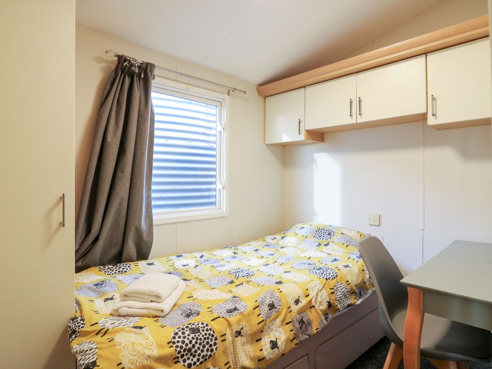 A bedroom with a bed and desk at Granada at Avalon Eco Farm, Cambridge