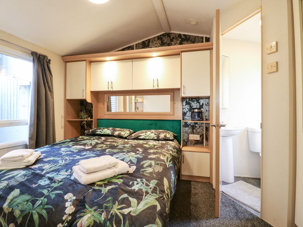 A bedroom with a bed and shelf units at Granada at Avalon Eco Farm, Cambridge