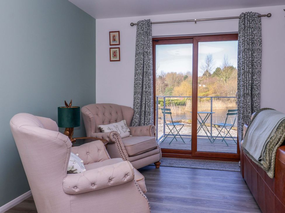 A living room with chairs and a sliding door at Star Carr Lakes