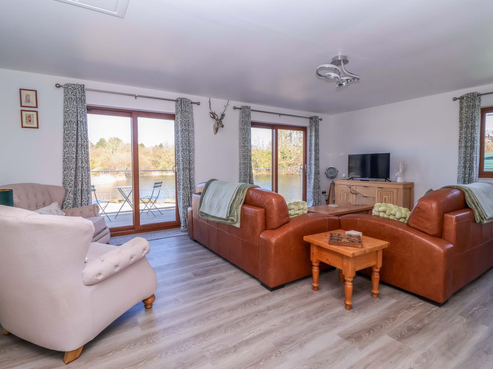 A living room with sofas and a TV at Star Carr Lakes
