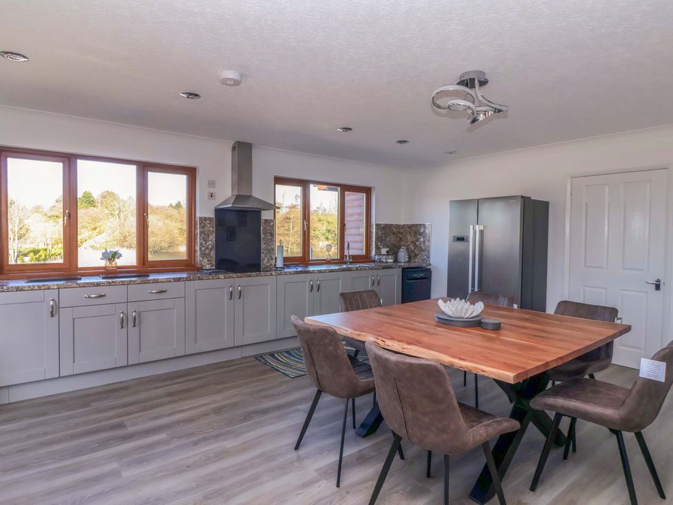 A kitchen with a dining table and chairs at Star Carr Lakes
