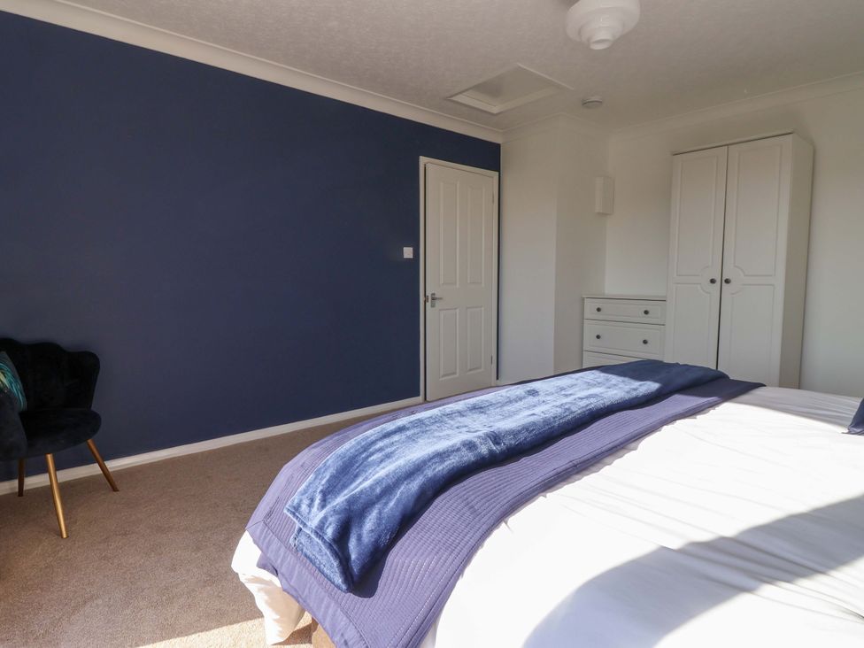 A bedroom with a bed and wardrobe at Star Carr Lakes