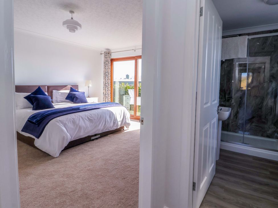 A bedroom with a bed and attached bathroom at Star Carr Lakes