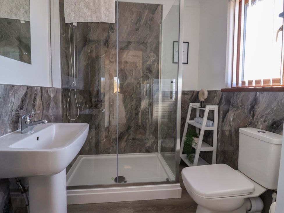 A bathroom with a shower, sink, and toilet at Star Carr Lakes