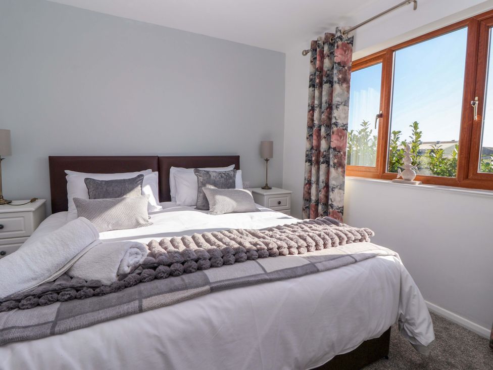 A bedroom with a double bed and window at Star Carr Lakes