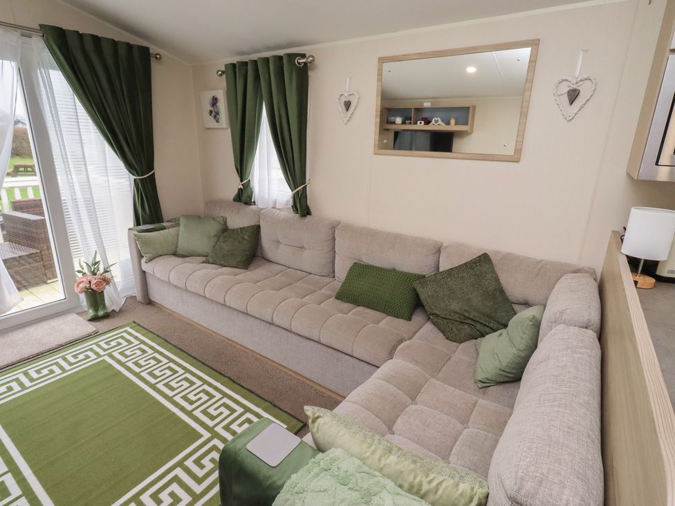 A living room with a sofa and window at Homeslea 33 Millennium Gardens in Morpeth