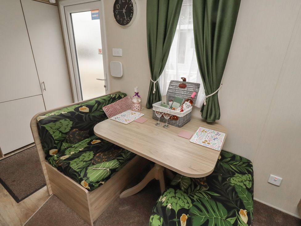 A dining room with a table and sofa at Homeslea 33 Millennium Gardens in Morpeth