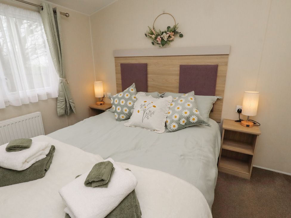 A bedroom with a bed and nightstand at Homeslea 33 Millennium Gardens in Morpeth