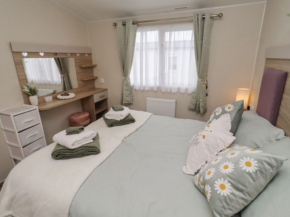 A bedroom with a bed and a dressing table at Homeslea 33 Millennium Gardens in Morpeth