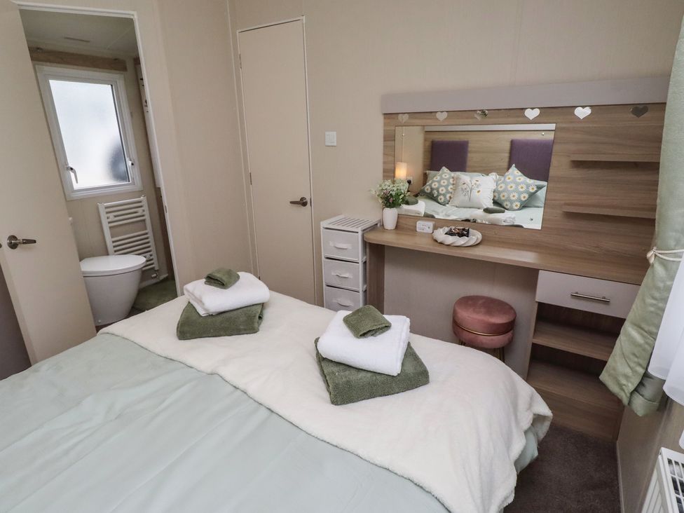 A bedroom with a bed and a dressing table at Homeslea 33 Millennium Gardens, Morpeth