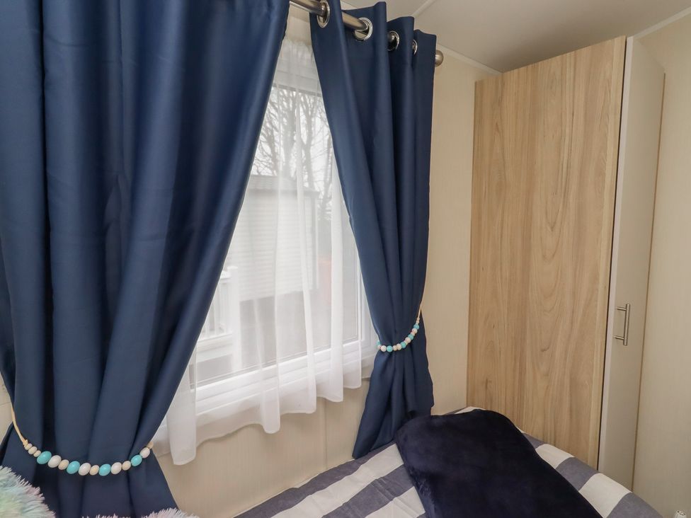 A bedroom with curtains and a wardrobe at Homeslea 33 Millennium Gardens in Morpeth