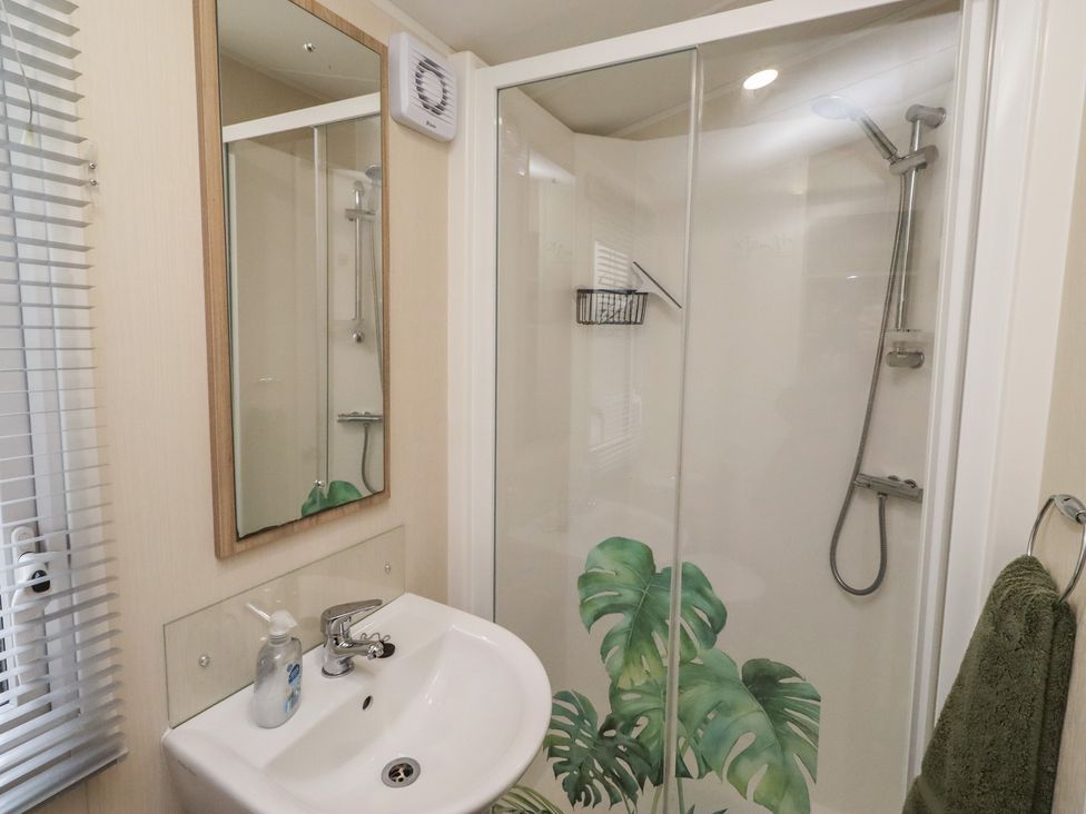 A bathroom featuring a sink, mirror, and shower at Homeslea 33 Millennium Gardens in Morpeth