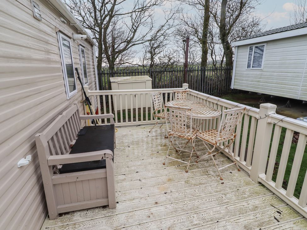An outdoor deck with a bench and table at Homeslea 33 Millennium Gardens in Morpeth