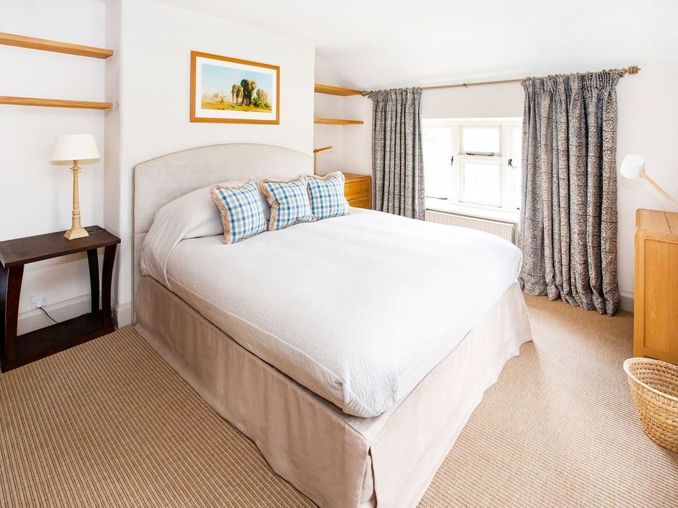 A bedroom with a bed and bedside table at Gardeners Cottage in Chipping Norton