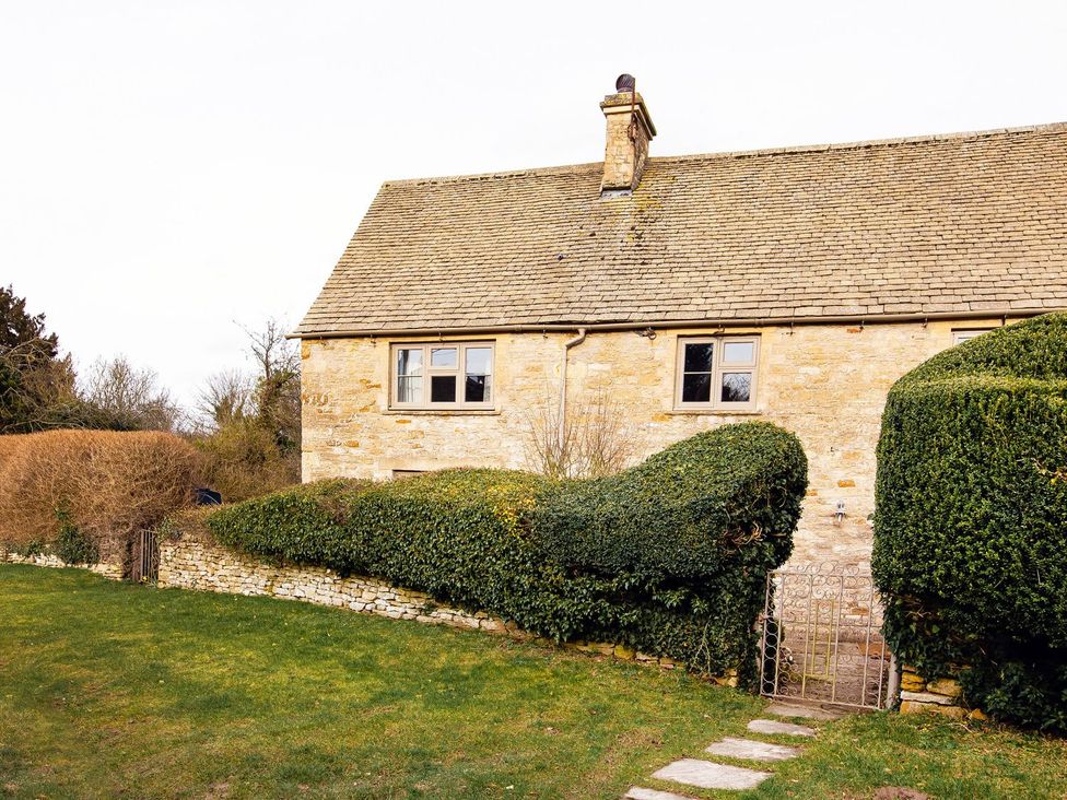 A house with a garden and hedges at Gardeners Cottage in Chipping Norton
