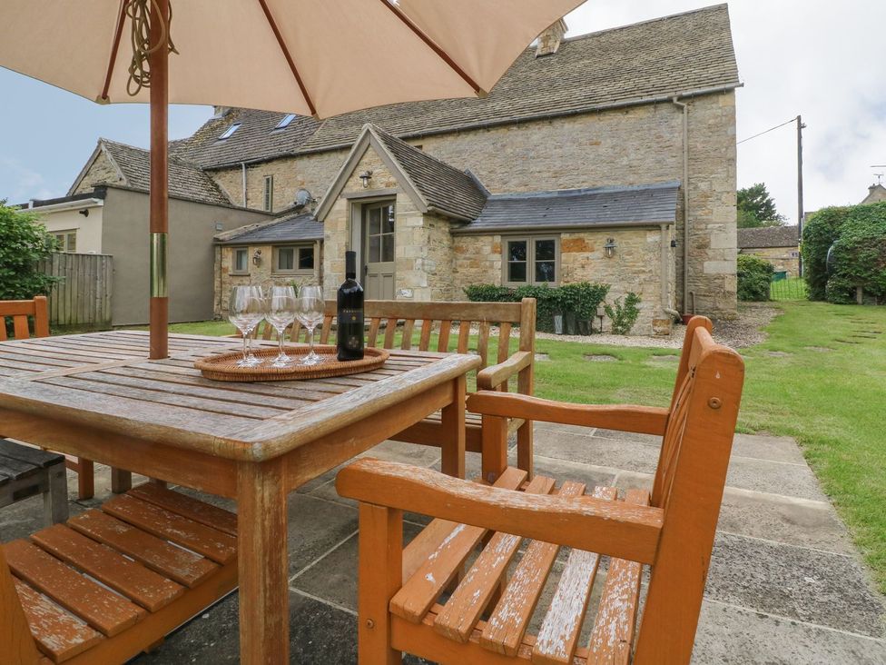 An outdoor dining area with a table and chairs at Gardeners Cottage in Chipping Norton