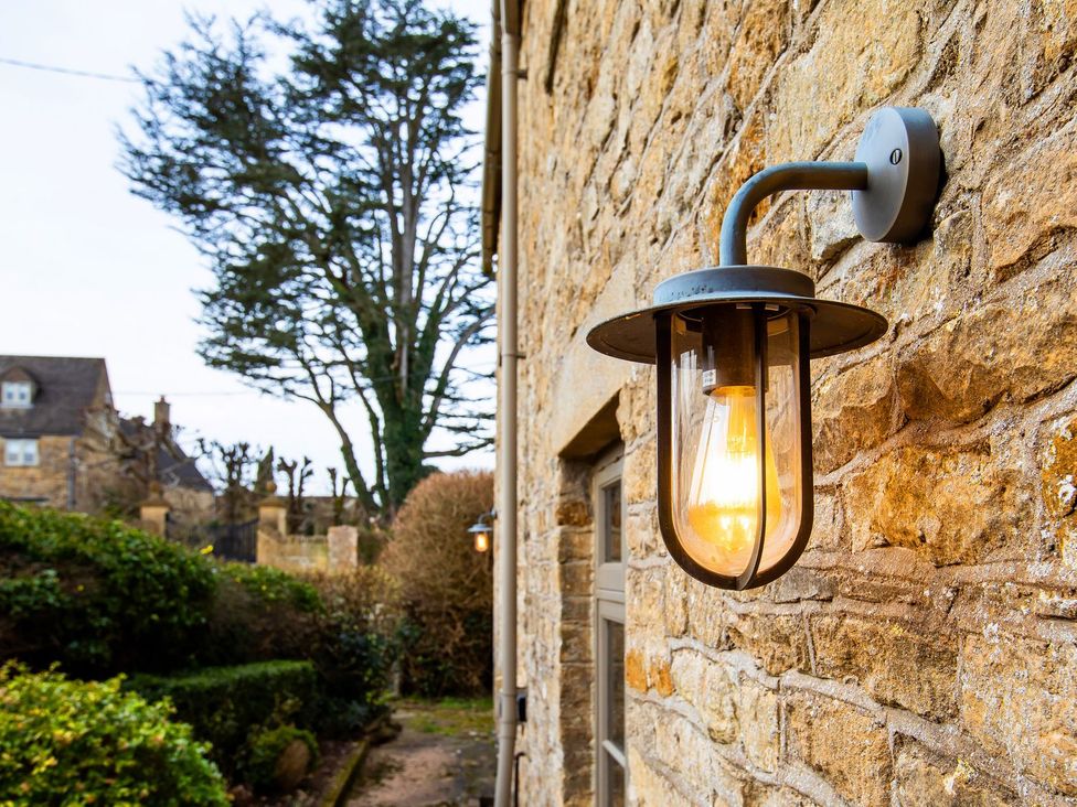 A light fixture mounted on a stone wall at Gardeners Cottage in Chipping Norton