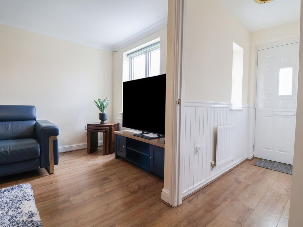 A living room with a sofa and television at 31 Llys Ogwen Prestatyn